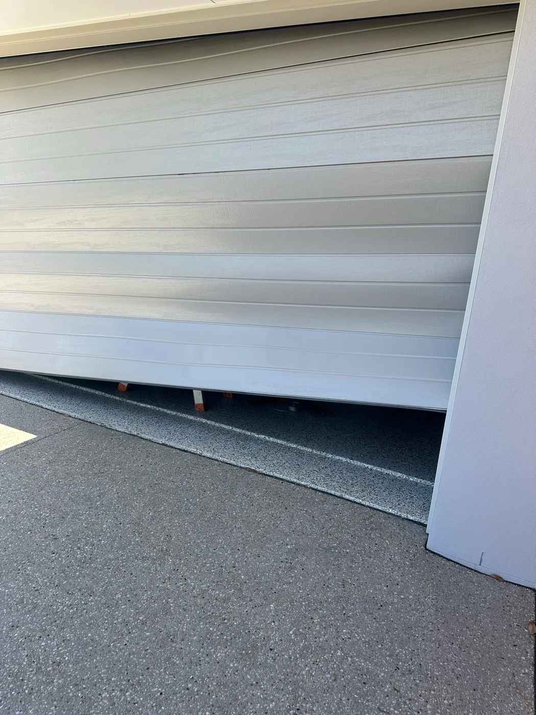 Technician repairing a roller garage door on a home near Coral Street in Tweed Heads