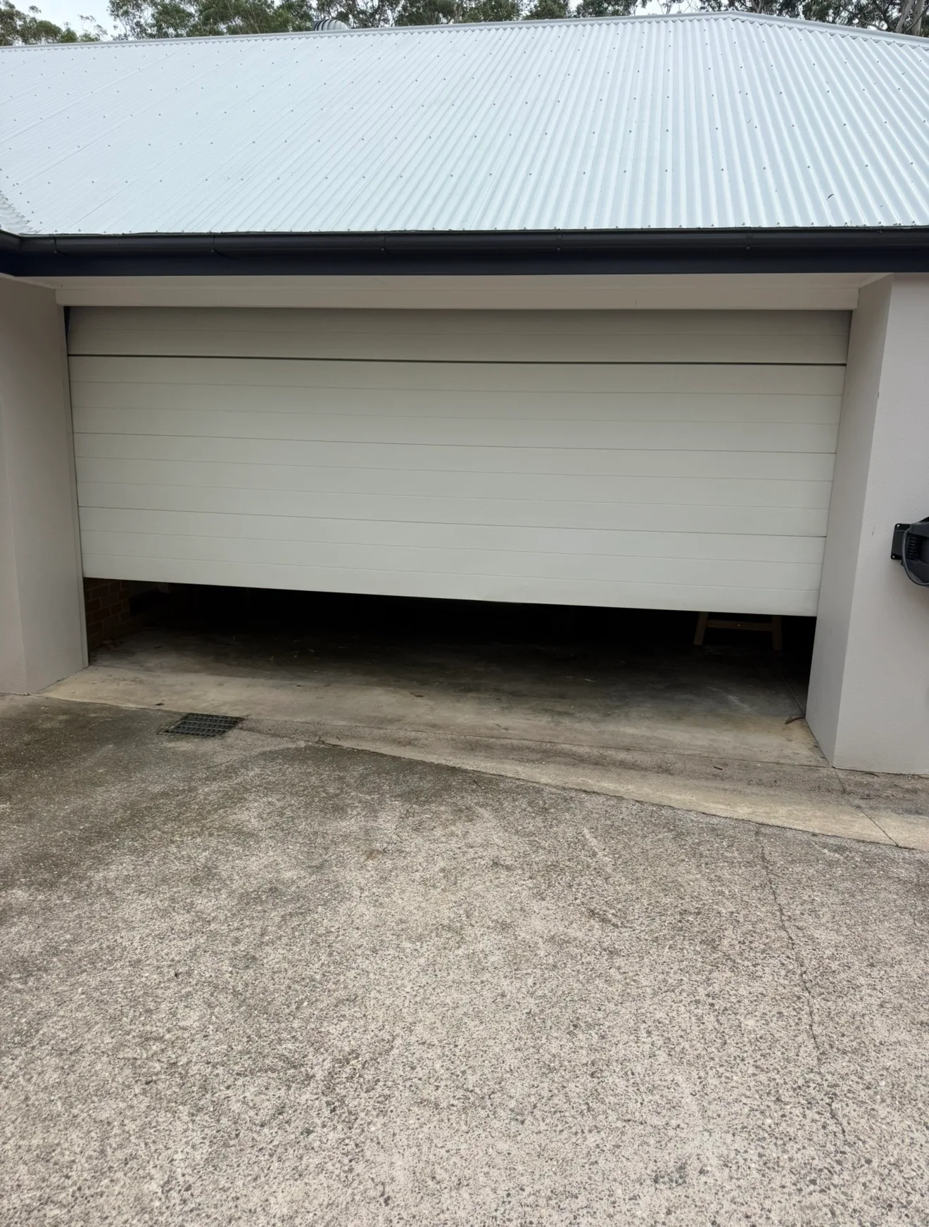 Garage door technician repairing a rural shed door on a small acreage property in Witheren