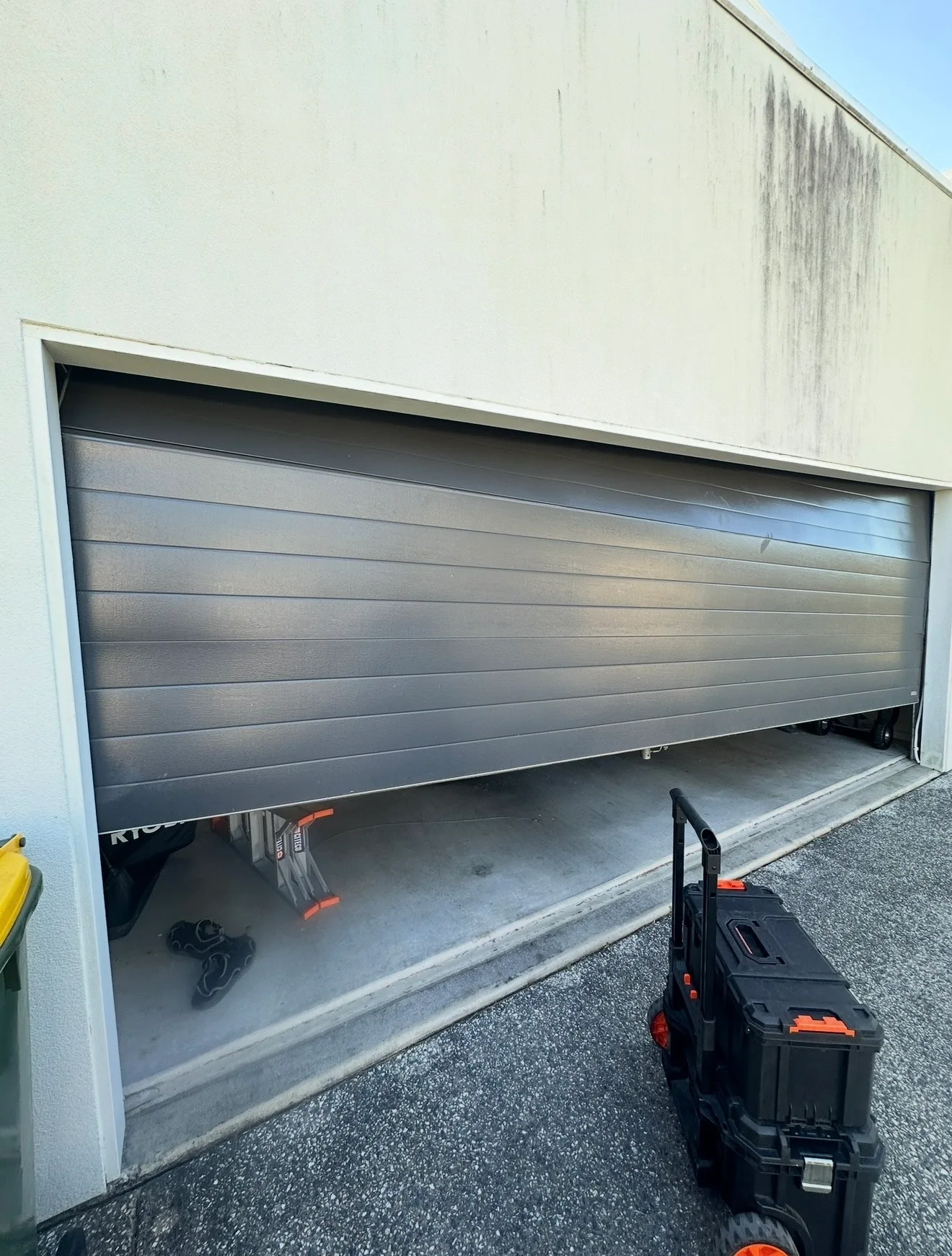 Technician servicing a garage door on a ridge-top acreage home in Terranora with hinterland views