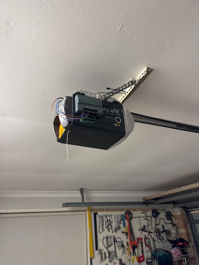 New Merlin receiver module wired onto a motor — same-generation receiver and remotes eliminate intermittent faults