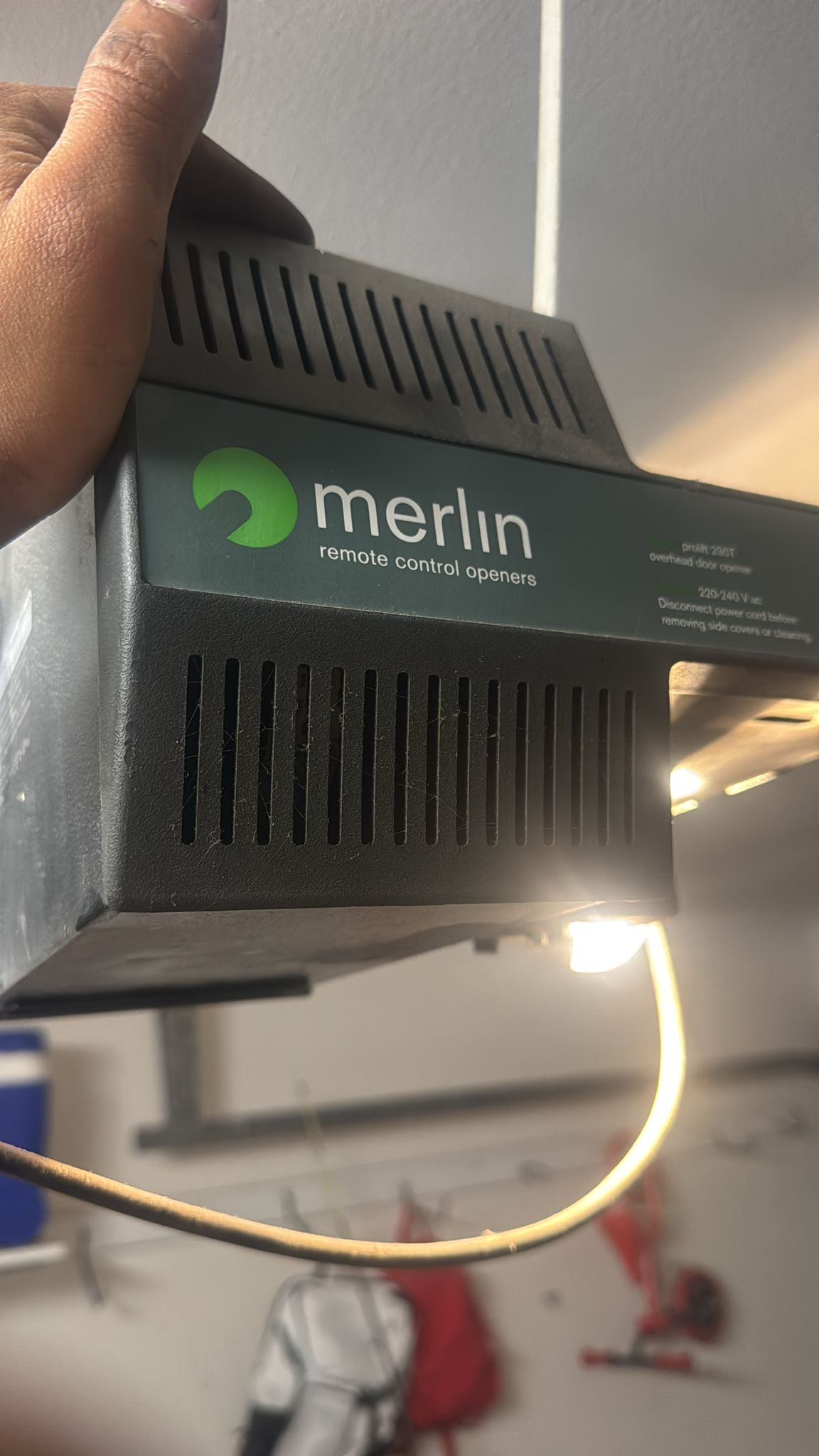 Old Merlin garage door motor being assessed for repair or replacement
