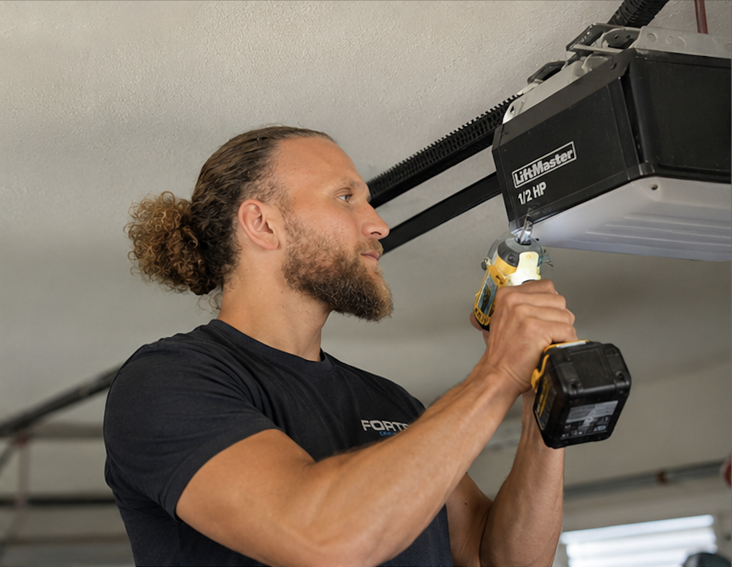 Fortex Door Services technician inspecting and adjusting garage door tracks on a Gold Coast home